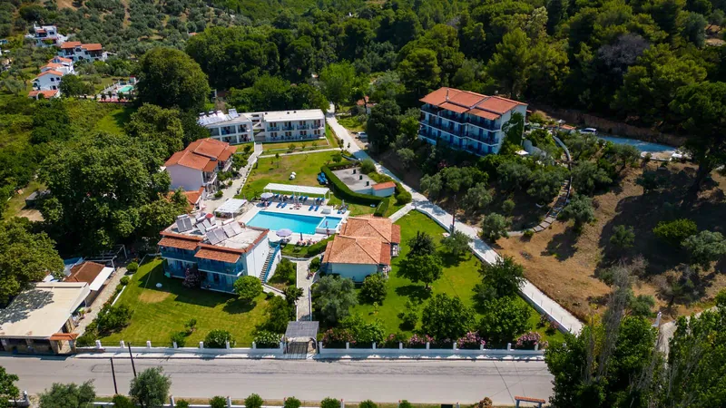 Hotel Morfia's buildings, gardens and pools among the trees of Troulos, seen from above